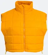 Chaleco cropped puffer color mostaza, con cuello alto y cierre frontal con cremallera.