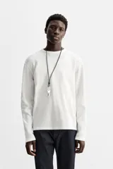Camiseta blanca de manga larga con cuello redondo y textura cuadriculada.