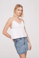 Musculosa blanca de breteles finos con detalles de encaje en el escote y bordado calado en el cuerpo.