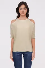 Sweater color crema de tejido de punto, con cuello redondo y hombros descubiertos.