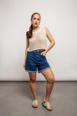 Blusa de tejido de punto calado color crema, sin mangas y corte crop.