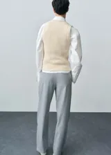 Chaleco de punto grueso color beige, sin mangas y con cuello redondo. Tejido con mezcla de lana responsable y corte slim fit.