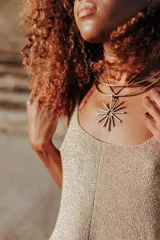 Gargantilla doble de bronce con dije en forma de sol.