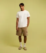 Remera de algodón color crudo, de corte recto y manga corta. Presenta un pequeño estampado con texto "Hawaiian Islands" en el pecho.