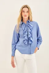 Camisa celeste de manga larga con volados en el frente y cuello clásico.