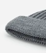Gorro corto tipo beanie color beige, tejido en lana acrílica con textura acanalada.