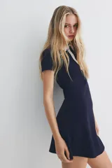 Vestido corto azul marino con cuello blanco, tapeta de botones y pollera acampanada.