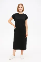 Vestido midi negro de algodón, corte holgado, manga corta y cuello redondo.