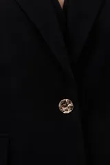 Blazer negro de corte clásico con solapas de muesca, cierre frontal con un botón y bolsillos con solapa.