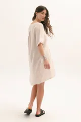 Vestido corto color arena, de lino, con escote en V y mangas cortas.