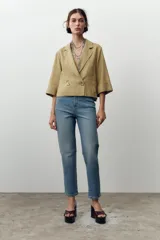 Jeans de tiro alto color celeste, corte mom fit, con cinco bolsillos y cierre frontal con cremallera y botón.