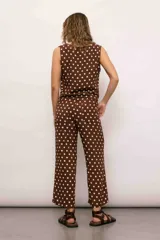 Blusa marrón con lunares blancos, escote en V y sin mangas.