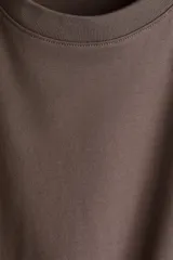 Remera marrón de corte recto en punto suave de algodón con cuello redondo ribeteado y hombros ligeramente caídos.