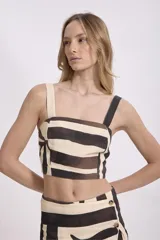 Falda midi color crema con estampado abstracto en tonos marrones y negros, de corte recto y con detalle de botón en la cintura.