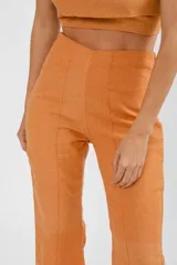 Pantalón de lino de corte flare color pomelo, con tiro alto y calce cómodo.