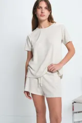 Short de punto color beige con cintura elástica y cordón ajustable.