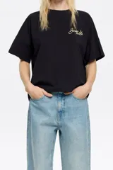 Camiseta negra de algodón con corte boxy, escote redondo y mangas cortas. Presenta el logo de la marca bordado en color dorado en el pecho.
