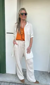 Camisa o sobrecamisa beige de fibrana con dos bolsillos frontales.