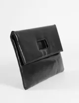 Sobre tipo clutch o cartera de mano, color marrón oscuro, con acabado brillante o charol. Presenta un diseño plegable con solapa superior que tiene un recorte cuadrado central, posiblemente para usar como asa o detalle decorativo. El material parece ser cuero sintético o charol.