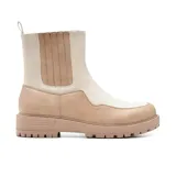 Bota Chelsea de cuero sintético charolado color negro, con elásticos laterales y tirador trasero. Tiene suela track y plataforma.