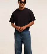 Pantalón baggy de jean azul, con bolsillos delanteros tipo cuchillo y bolsillos traseros.