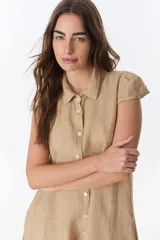 Vestido camisero celeste de lino, corte midi, con cuello camisero, mangas cortas con volados y abotonadura frontal.