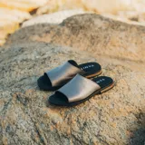 Sandalias bajas de cuero vacuno color negro, con suela de goma y horma de punta redonda. Producto de horma chica, se recomienda pedir un talle más.