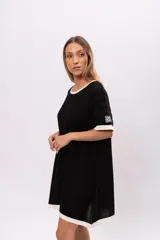Vestido corto negro de tejido de punto calado, con cuello redondo y mangas cortas con ribete blanco.