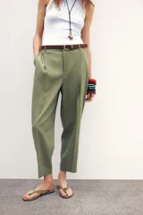 Pantalón blanco de lino, de tiro alto con pinzas delanteras, bolsillos frontales y falsos bolsillos con solapa en la espalda. Incluye cinturón marrón.