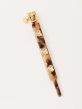 Pulsera regulable con estampado animal print y apliques de corazones dorados.