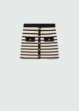 Minifalda de punto a rayas horizontales en color crema y negro, con ribetes en contraste. Presenta dos bolsillos de solapa con botón dorado en la parte delantera y botones decorativos.