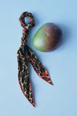 Pañuelo de viscosa con estampado animal print y borde fucsia.