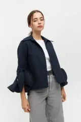 Camisa negra con cuello clásico y mangas largas con detalle de volados en los puños.