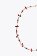 Set de tres pulseras tobilleras metálicas doradas con abalorios de diferentes colores y formas.