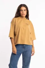 Remera blanca de corte cuadrado con cuello subido y mangas 3/4 amplias.