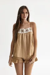 Top mostaza amplio con breteles regulables y aplique de crochet en la pechera.