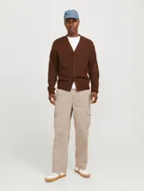 Pantalón cargo color beige de pierna ancha con fit amplio y tiro medio alto. Cuenta con bolsillos delanteros, traseros y laterales, cierre con cremallera y puños doblados.