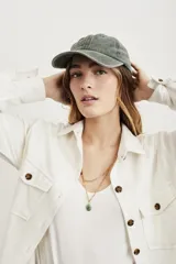 Gorra verde oliva de algodón lavado, estilo béisbol, con visera curva y correa ajustable en la parte trasera.