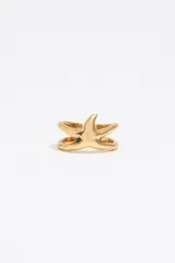 Anillo dorado con forma de estrella de mar con textura y logo grabado.