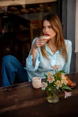 Camisa color beige con bordado inglés, de corte recto, manga larga abullonada con puño y cuello camisero.