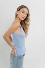 Musculosa amarilla de hilo con brillo sutil, de calce ajustado y breteles finos.