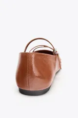 Zapato tipo bailarina color marrón de piel con acabado charol. Tiene punta cuadrada, detalle de tiras con hebillas metálicas y suela plana.