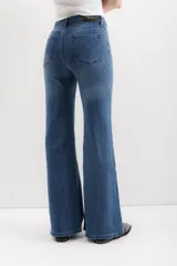 Pantalón de jean azul de corte acampanado, tiro alto y cinco bolsillos.
