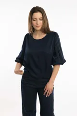 Blusa azul marino con cuello bote y mangas amplias con elástico en los puños.