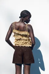 Shorts de jean blancos, tiro medio, corte mom fit, con cinco bolsillos y cierre frontal con cremallera y botón.