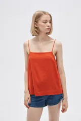 Blusa de lino color naranja, de corte ancho y cuello recto, con breteles finos.