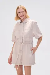 Mono corto blanco de algodón, con cuello camisero, cierre frontal con botones, mangas cortas y bolsillos.