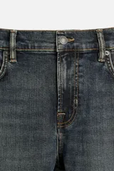 Pantalón de jean azul oscuro, corte slim fit, tiro medio, cinco bolsillos, tejido elástico y efecto lavado.