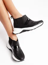 Sneaker negro formal, liviano y cómodo, con elásticos laterales y suela de goma antideslizante.