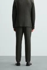 Pantalón de vestir azul marino, de corte recto, confeccionado en lino. Tiene bolsillos laterales y traseros con botón.